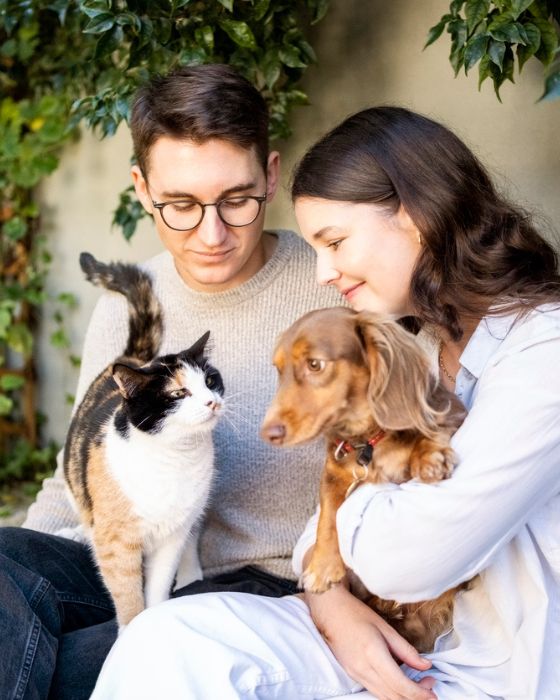 chien et chat sur les genoux d'un couple