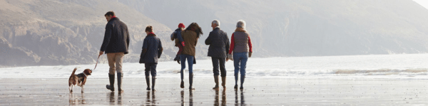 chien en balade sur la plage en famille